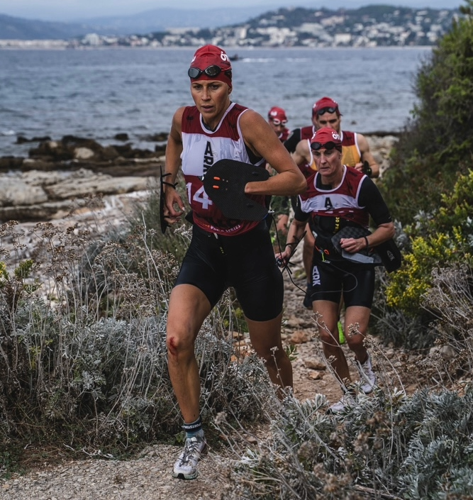 KRISTIN LARsson running along a rocky coastline during a swimrun race